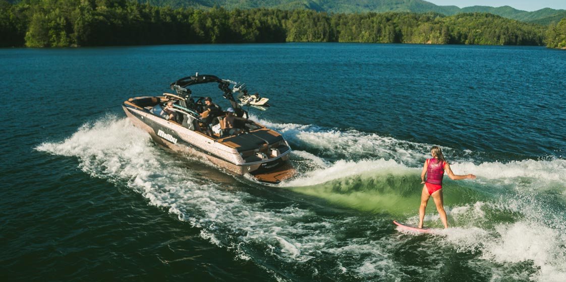 Woman wakesurfing behind a Malibu Boat